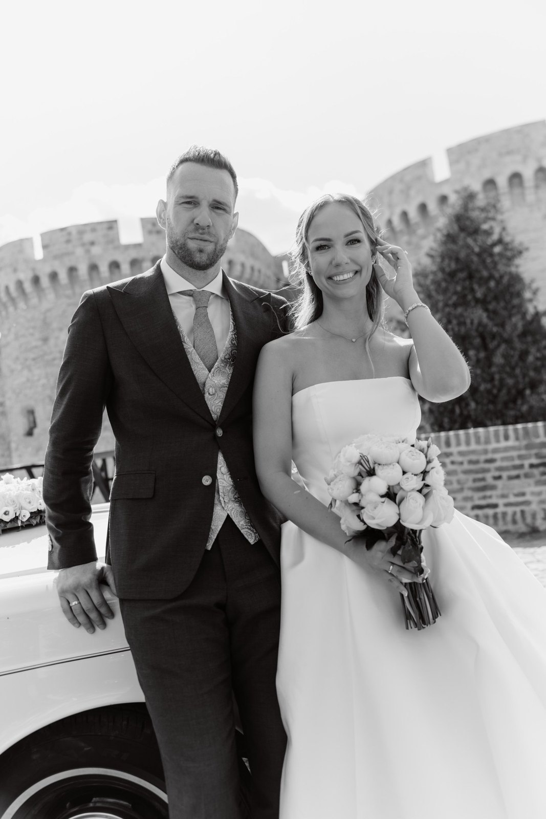 Jelena & Dejan, Klasična venčanja in 2023, 2023 — Mladenci pored automobila, crno-beli portret posle ceremonije — planned and designed by…